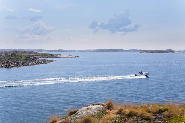 Scenic view of people in boat traveling by coastline — Stock Photo