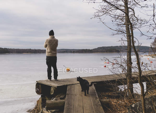 Vue arrière de l'homme debout près de l'eau, mise au point sélective — Photo de stock