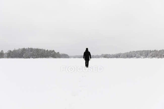 Woman walking on snow covered Stora Skiren lake in Lotorp, Sweden — Stock Photo