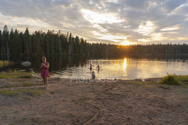 Друзі біля озера на заході сонця, вибірковий фокус — стокове фото
