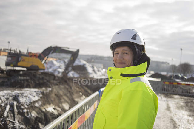 Mujer sonriente en el sitio de construcción - foto de stock