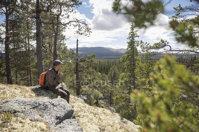 Caballero sentado en las rocas, enfoque selectivo - foto de stock