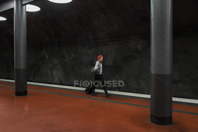 Jeune femme avec valise à la station de métro — Photo de stock