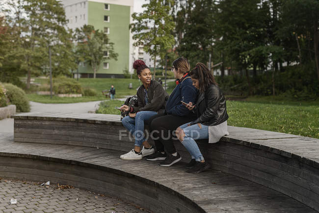Amici seduti insieme nel parco, focus selettivo — Foto stock