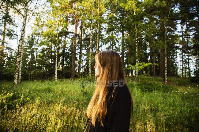 Young woman in forest at sunset — Stock Photo