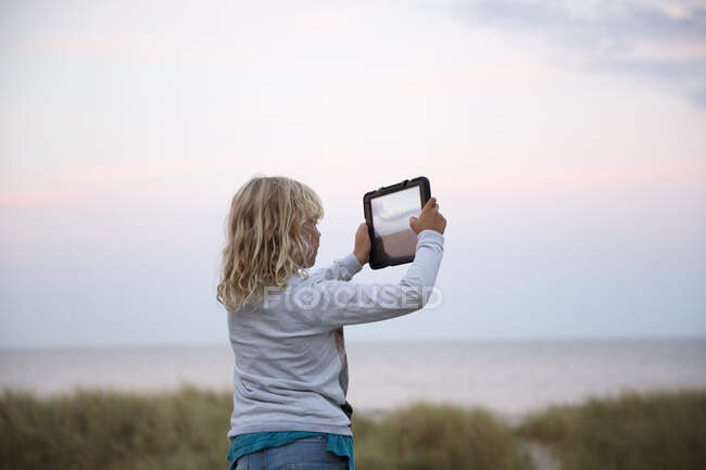 Girl taking photograph with tablet PC — Stock Photo