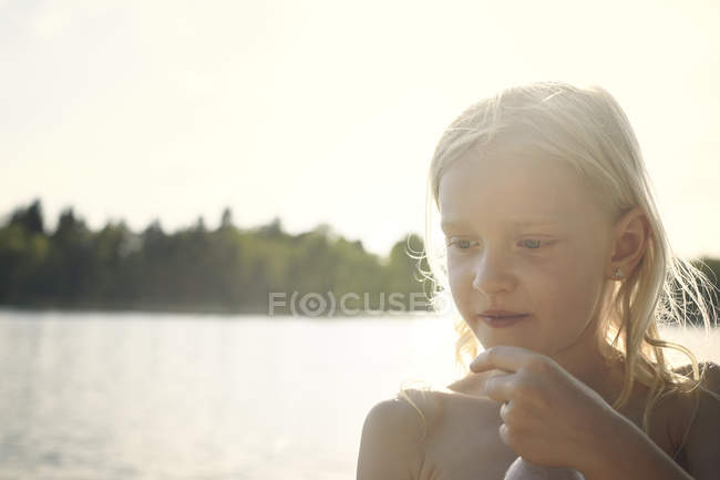 Mädchen wieder vom Sonnenstrahl vor dem See angezündet — Stockfoto