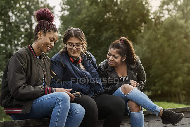 Teenage girls using smart phone — Stock Photo