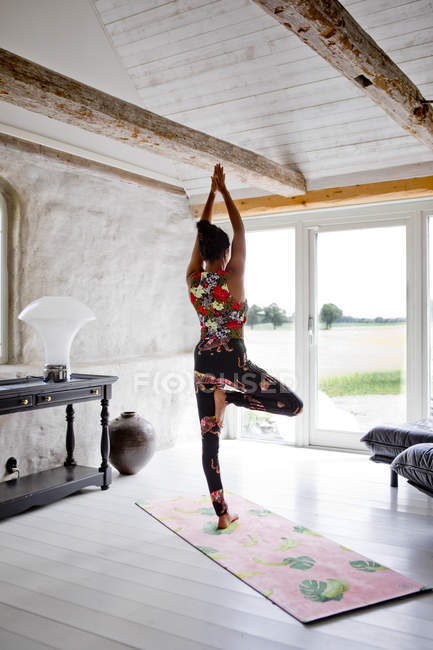 Женщина практикует йогу в гостиной — стоковое фото