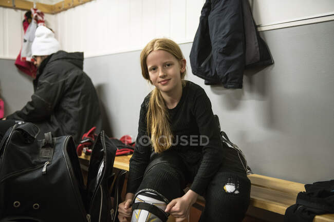 Fille dans le vestiaire se préparant pour l'entraînement de hockey sur glace — Photo de stock