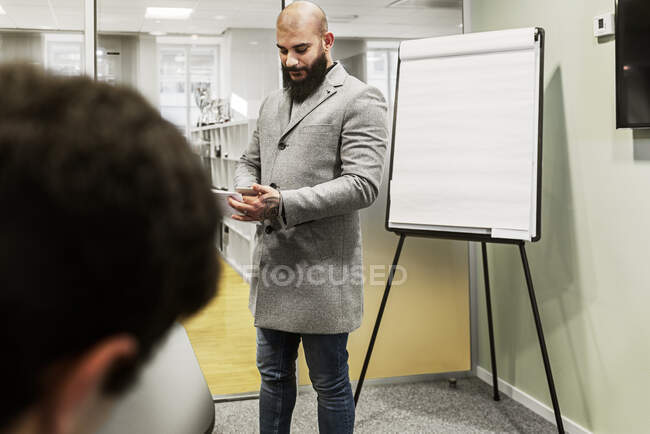 Homem usando smartphone na sala de conferências — Fotografia de Stock