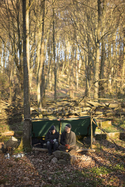 Hombres acampando en bosque, enfoque selectivo - foto de stock