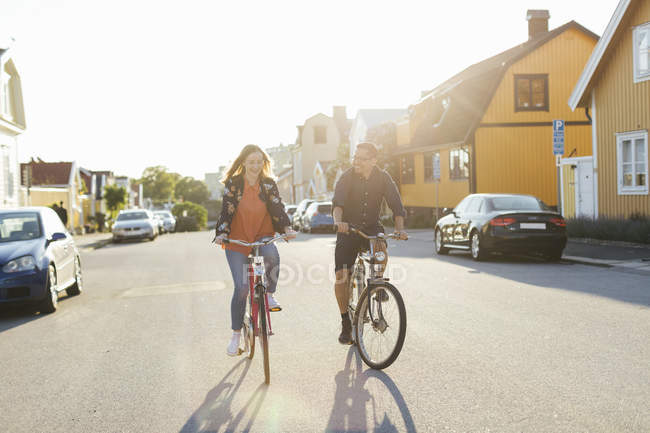 Couple à vélo sur la rue de banlieue — Photo de stock