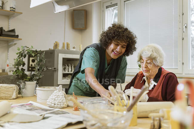 Senior woman making pottery in nursing home — Stock Photo