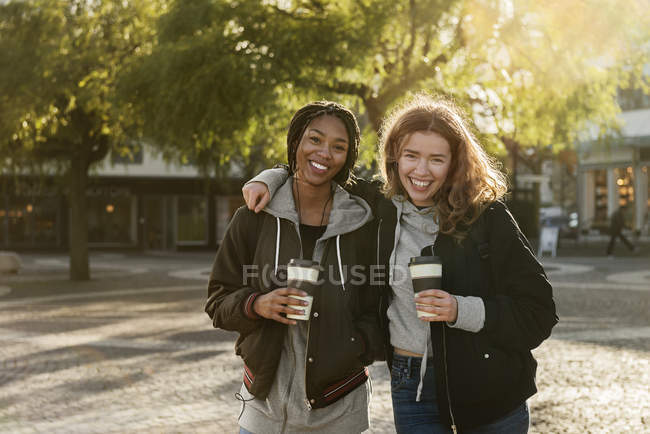 Улыбающиеся девочки-подростки с кофейными чашками — стоковое фото
