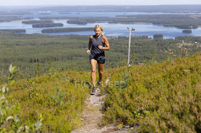 Женщина, бегущая по холму — стоковое фото