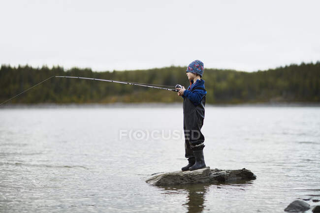 Entzückender kleiner Junge angelt im Fluss — Stockfoto