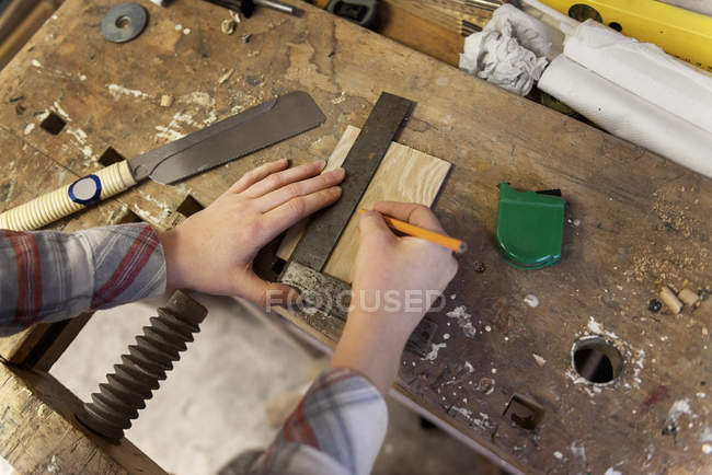 Hands of carpenter marking measurement — Stock Photo