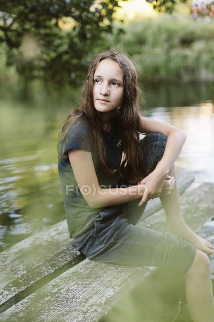 Girl sitting on jetty, selective focus — Stock Photo