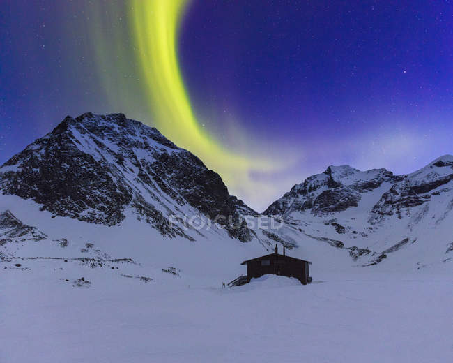 Luces boreales sobre montañas cubiertas de nieve en Laponia, Suecia - foto de stock