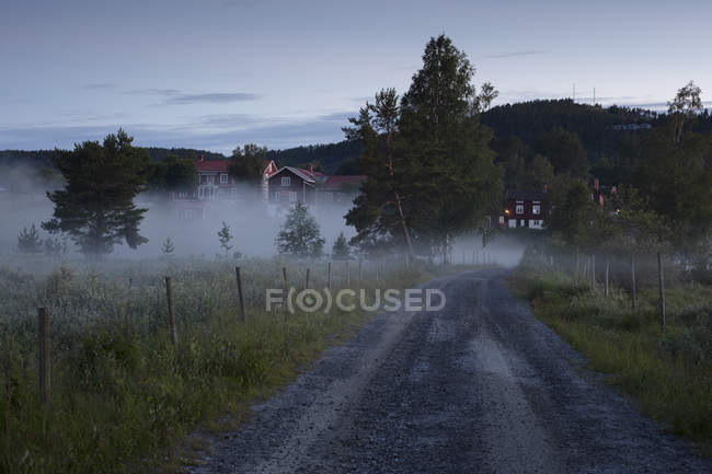 Vue panoramique de la route rurale dans la brume — Photo de stock