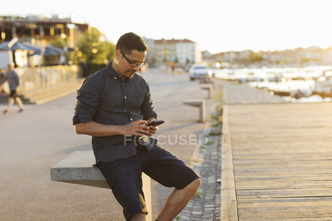 Чоловік використовує смартфон на прогулянці — стокове фото