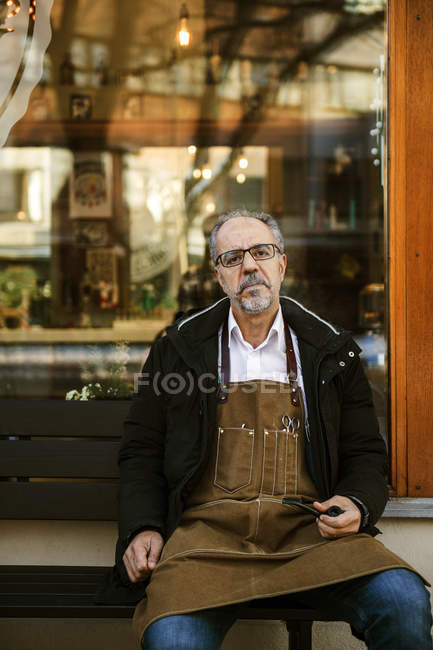 Barber sitting outside barbershop, selective focus — Stock Photo