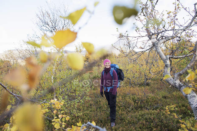 Woman hiking by autumn trees, selective focus — Stock Photo