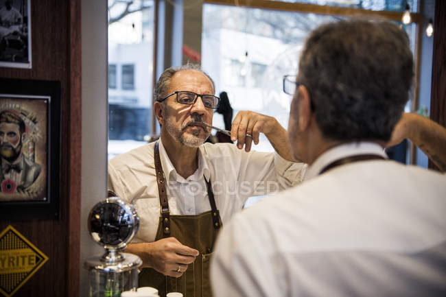 Barber trimming mustaches, selective focus — Stock Photo