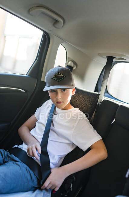 Carino ragazzo adolescente seduto in auto e guardando la fotocamera — Foto stock