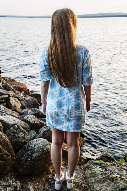 Молодая женщина стоит на берегу озера — стоковое фото