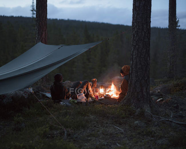 Men by campfire, selective focus — Stock Photo