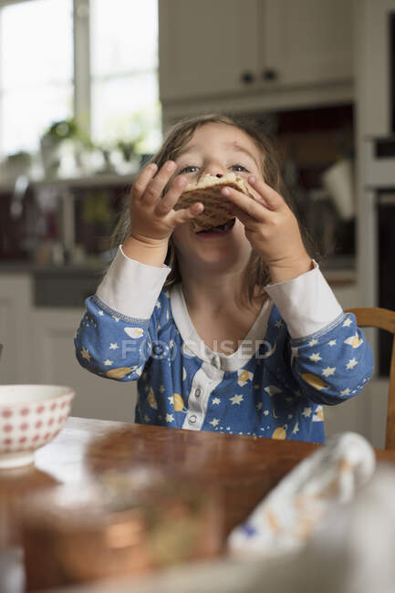 Дівчина їсть смачний сніданок вдома — стокове фото
