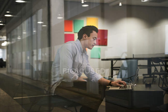 Молодий чоловік використовує ноутбук, вибірковий фокус — стокове фото