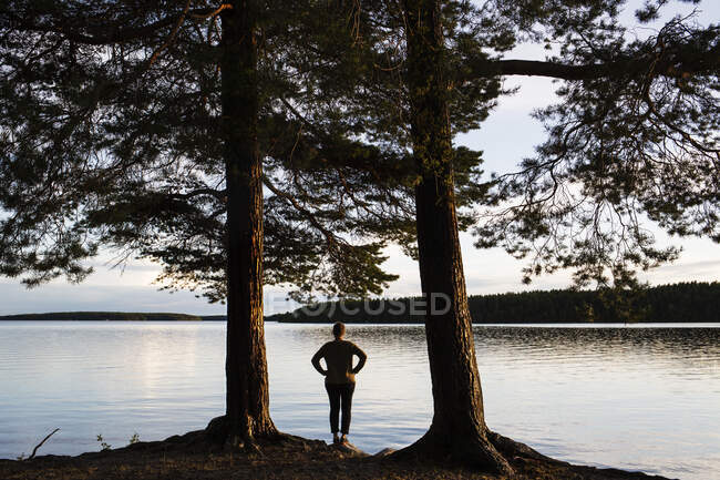 Maduro mulher de pé ao lado de lago volta vista — Fotografia de Stock