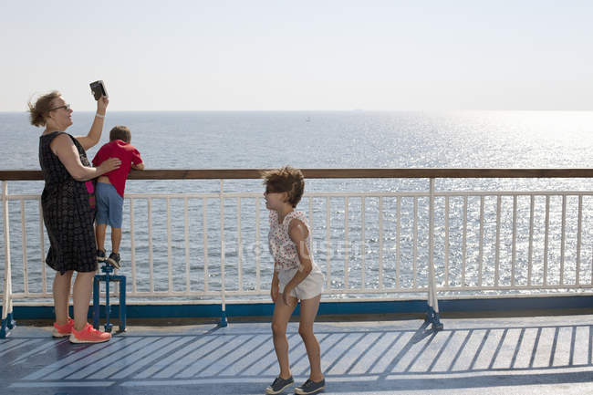 Woman with grandchildren by sea, selective focus — Stock Photo