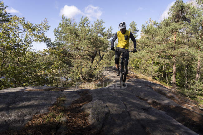Homem de bicicleta através da floresta, foco seletivo — Fotografia de Stock
