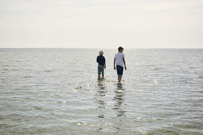 Chicos vadeando en el mar, enfoque selectivo - foto de stock