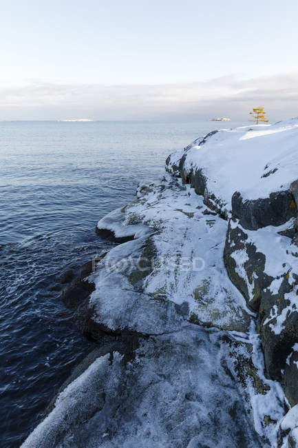 Vista panorâmica da neve em rochas por mar — Fotografia de Stock