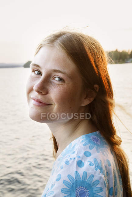 Portrait de jeune femme avec lac en arrière-plan — Photo de stock