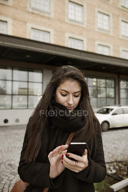 Junge Frau nutzt Smartphone — Stockfoto