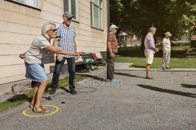 Personas mayores jugando petanca al aire libre - foto de stock