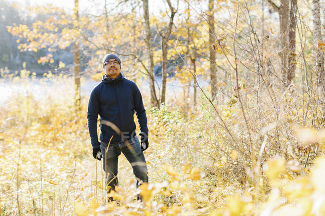 Mann trägt blaue Jacke zwischen Herbstbäumen — Stockfoto