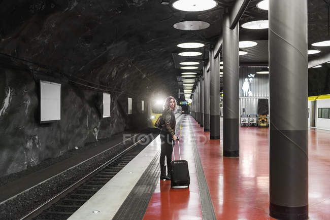 Jovem com mala na estação de metrô — Fotografia de Stock
