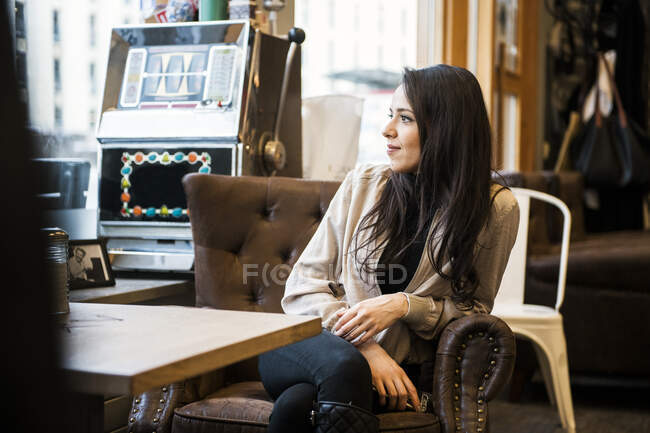 Young woman sitting at table in barbershop — Stock Photo