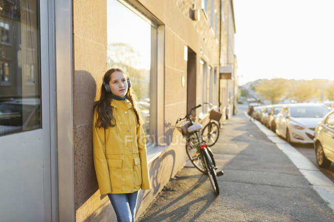 Girl wearing headphones on sidewalk — Stock Photo