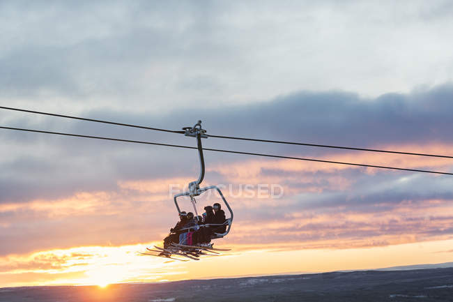 Silhouettes of people on ski lift, selective focus — Stock Photo