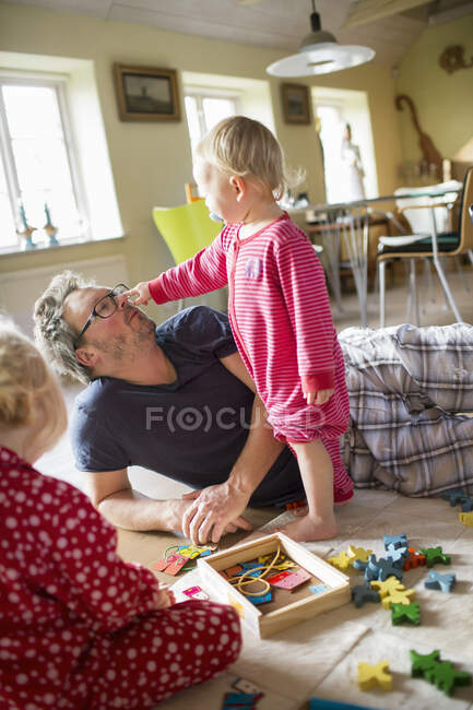 Homem brincando com suas filhas em casa — Fotografia de Stock