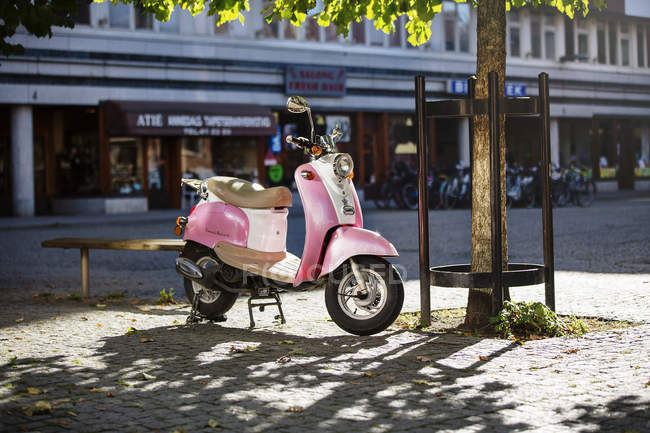 Pink scooter in public square — Stock Photo