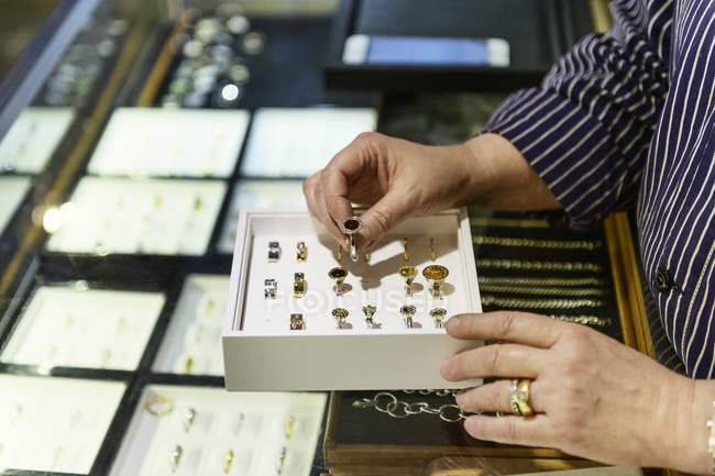 Mãos de ourives examinando caixa de anéis — Fotografia de Stock